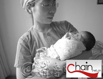　　　　　　　　　　护士怀中的女婴多多。　本报记者　张榕博　摄