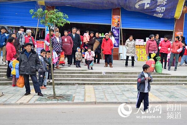 在镇上，几乎很多人都知道坤坤这个艾滋病男童，当坤坤从便利店出来后，大家自然地与他产生一定的距离。（陈永斌摄）