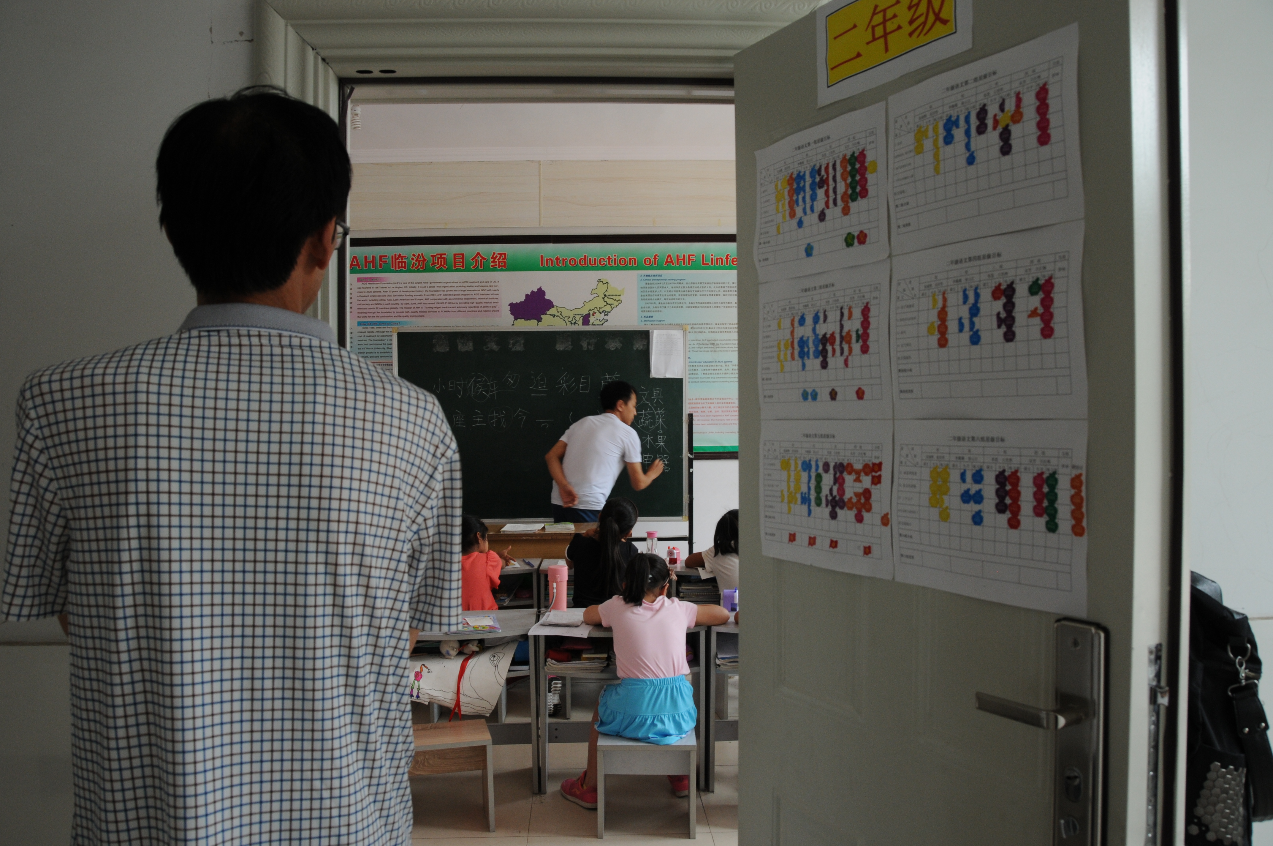 郭小平在教室外面看小学二年级学生上课（6月16日摄）。新华社记者 王学涛 摄